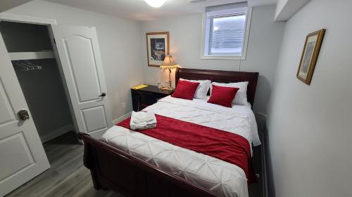 坎布里奇LUXURY 2-BEDROOMS UNIT WITH WIFI, LDR & PARKING.的小卧室配有红色枕头的床