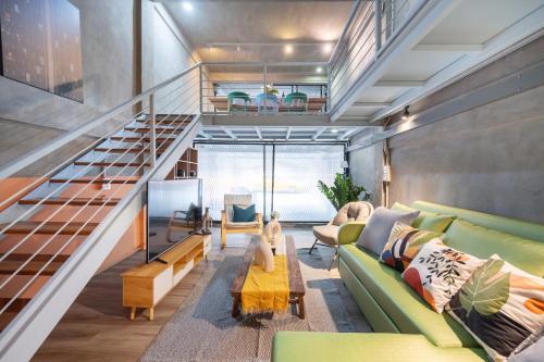 曼谷MIQ Ekkamai2 3BR Designer home Oval Bathtub 15pax的客厅设有绿色沙发和楼梯。