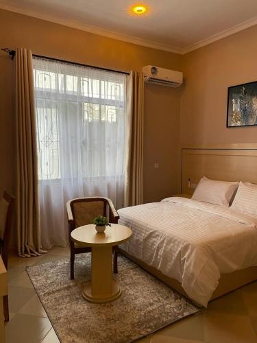 多多马Rosa Hotels的一间卧室配有一张床、一张桌子和一个窗户。