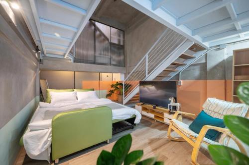 曼谷MIQ Ekkamai2 3BR Designer home Oval Bathtub 15pax的一间卧室配有一张床、一台电视和一把椅子
