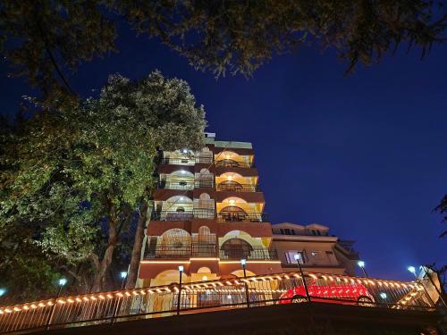 西姆拉Hotel Taj Palace near Mall Road的一座高大的建筑,晚上有灯