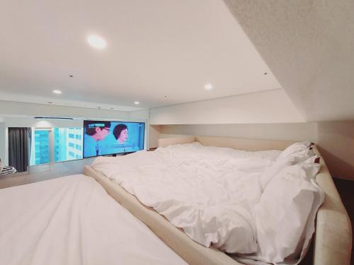 首尔Coex Stay的一间配有电视的客房内的一张大白色床