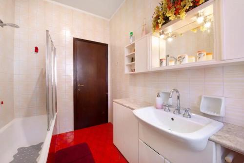 科莫Appartamento House of Roses con vista Duomo的白色的浴室设有水槽、浴缸和水槽。