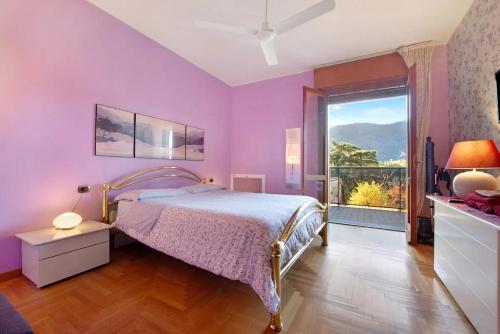 科莫Appartamento House of Roses con vista Duomo的紫色卧室设有一张床和一个大窗户