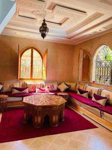 马拉喀什Villa Paradis的带沙发、桌子和窗户的客厅