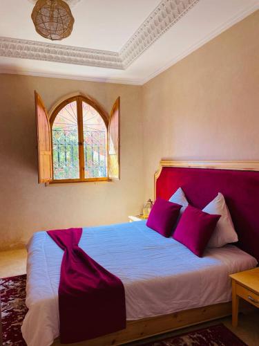 马拉喀什Villa Paradis的一间卧室配有一张带紫色枕头的大床