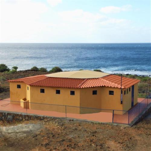 CarriçalCasa Tartaruge + Casa Pardal的海边的黄色房子,有红色屋顶