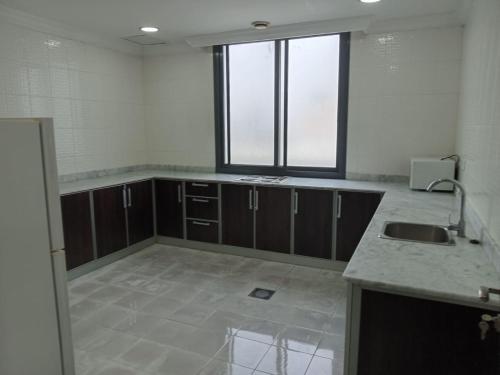 阿尔科兰Al Salam Resort的一个带水槽和窗户的空厨房