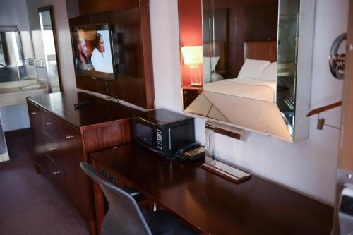 CollinsvilleRelax Inn的客房设有一张桌子、一台电视和一张床