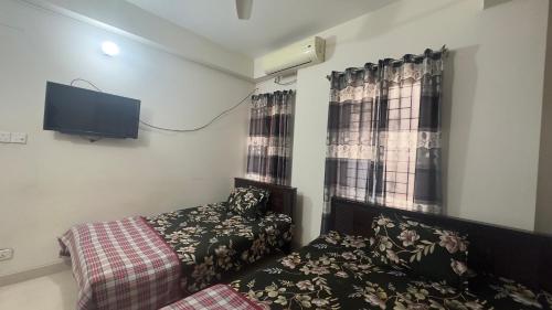 达卡Appayan Guest House (Baridhara)的一间卧室配有一张床和一台平面电视