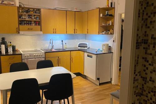 特罗姆瑟Skogstad Ferie og fritid的厨房配有黄色橱柜和桌椅