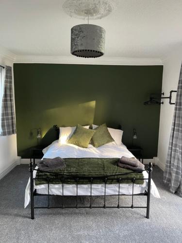 米德尔斯伯勒Upsall Warren Cottage的一间卧室配有一张带绿色墙壁的床