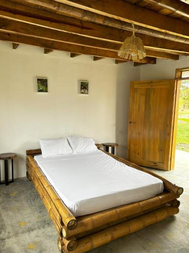 IsnosFinca el Manantial Isnos, habitación Alas de Chocolate的木架客房内的一张床位