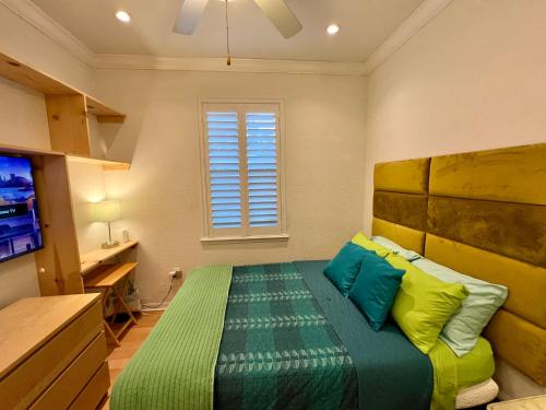 Lake AlfredThe Scandinavian Contemporary Blauw的一间卧室配有一张带绿色和黄色枕头的床