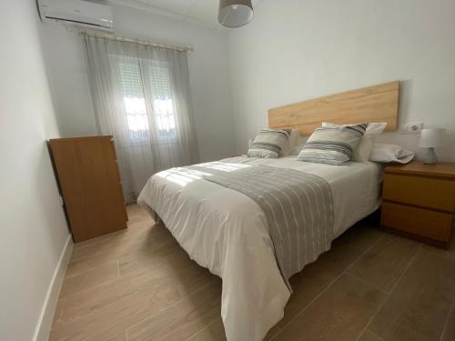 阿拉色那Aracena Flat Noria的一间卧室配有一张大床和木制床头板