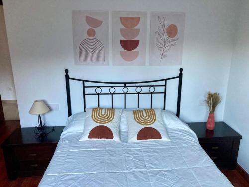 萨米艾拉Apartamento con jardín y piscina temporada verano privados的卧室内的一张带两个枕头的床