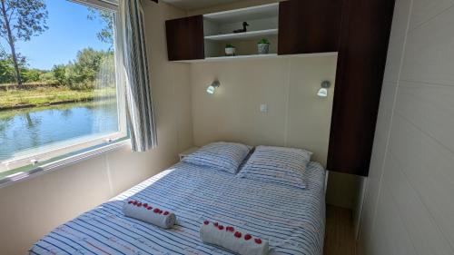 Cottage flottant terrasse gamme supérieure option jacuzzi proche Dijon的一个小房间的小床,设有窗户