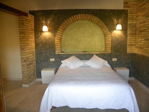 阿尔克萨尔卡萨雅柏内罗旅舍的卧室配有白色的床,上面有拱门
