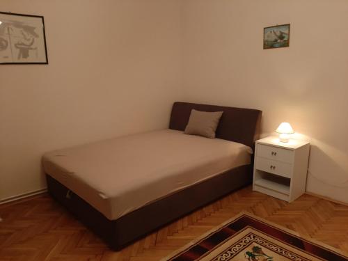 鲍洛通凯赖斯图尔Új Élet Weekend house的一张小床,位于一个设有床头柜的房间