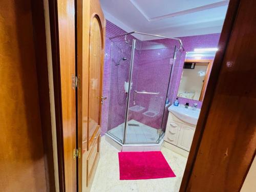 马拉喀什Chez Alex的带淋浴的浴室和红色地毯。