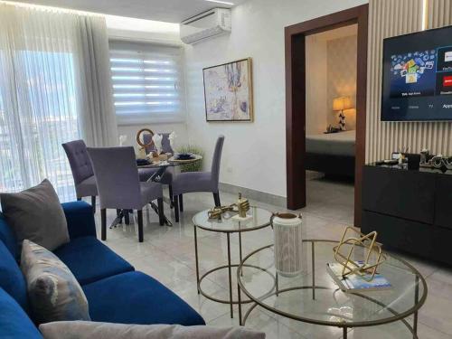 圣地亚哥洛斯卡巴Soha Suites Santiago Gem Rare Find的客厅配有蓝色的沙发和电视