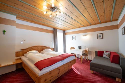拉德施塔特科斯雷尔旅馆的一间卧室配有一张大床和一张桌子