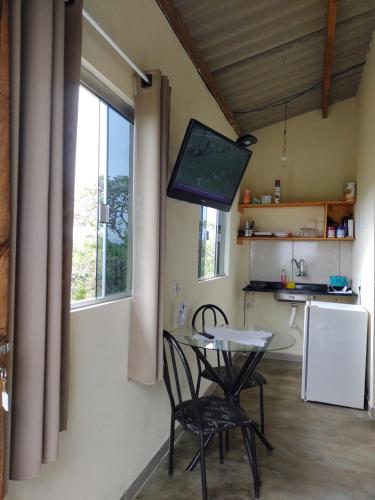 戈亚斯州上帕莱索Chalé pôr do Sol的厨房配有桌椅和电视。