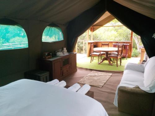 维德尼斯Wilderness Glamping Tents的一间卧室配有带桌椅的帐篷