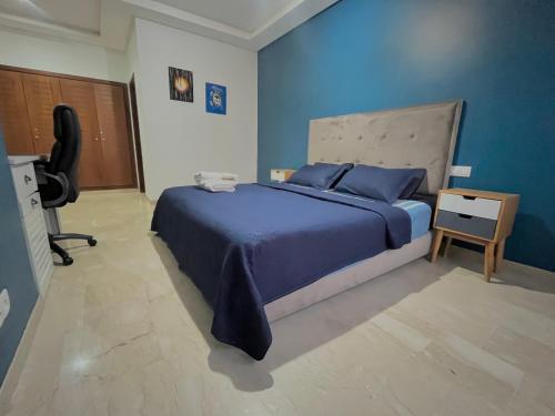 诺阿瑟Luxury résidence Taj Nouaceur的蓝色卧室配有一张床和一张书桌