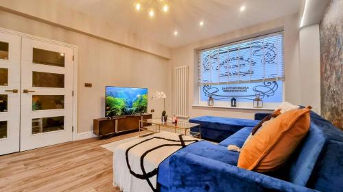 布莱顿霍夫Stylish 4 bed townhouse的客厅配有蓝色的沙发和电视