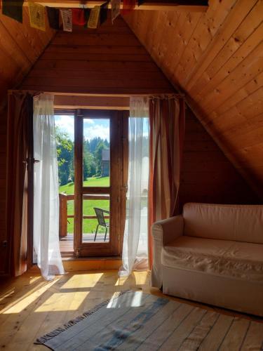 布泽吉DZIUPLA - Berghaus in der Tatra mit Holzsauna的带沙发和大窗户的客厅