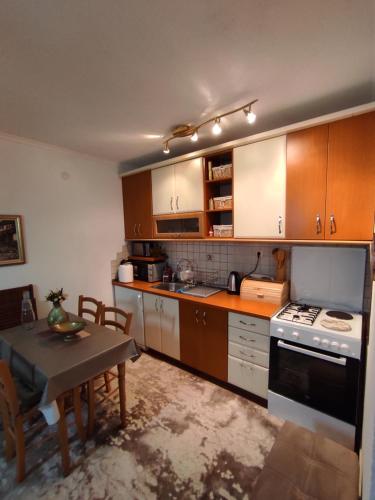弗拉西克Apartman Royal Vlašić的一间带木制橱柜和桌子的厨房以及一间用餐室