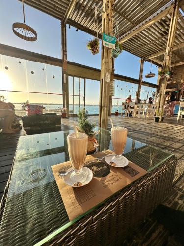 拉塞雷纳Dpto en Resort Laguna del Mar frente al mar 2D2B的玻璃桌,上面有两杯