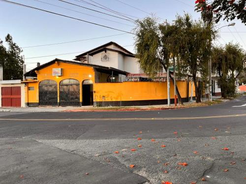 危地马拉Hotel Canaan La aurora的街道边的橙色建筑