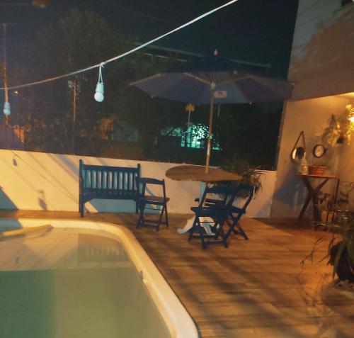 伊达贾伊Casa com Piscina的一个带桌椅和遮阳伞的游泳池