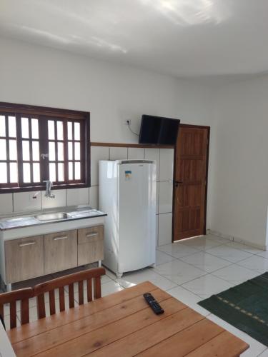 伊利亚贝拉Mazz_q_casa的厨房配有白色冰箱和木桌