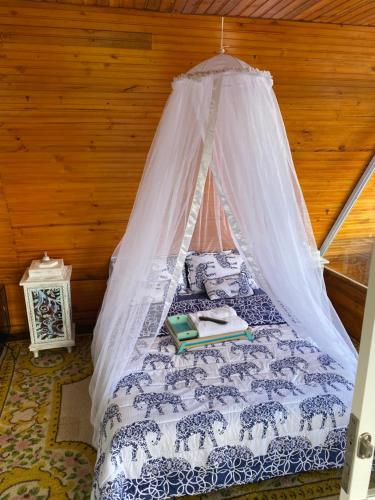 Hermosa cabaña para parejas cerca a Tuluá con jacuzzi的一间卧室配有一张带蚊帐的床