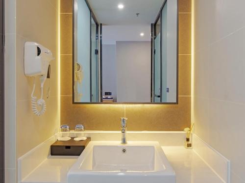 海盐嘉兴海盐科技城兰欧酒店的浴室设有白色水槽和镜子