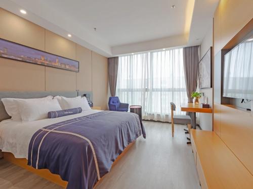 海盐嘉兴海盐科技城兰欧酒店的一间卧室配有一张大床和电视
