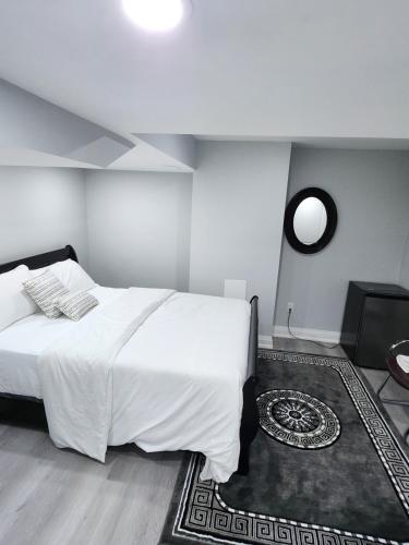 布兰普顿SUITE A 2 Bedroom Apartment的卧室配有一张白色大床和镜子