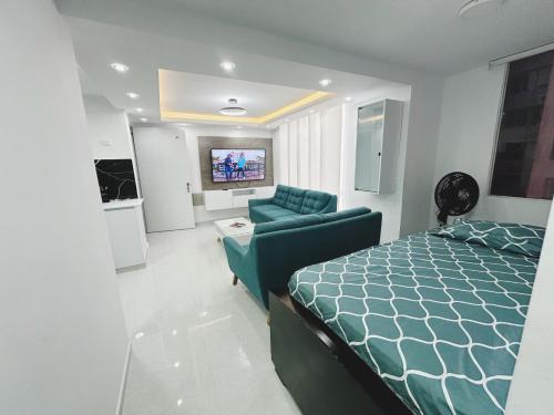 巴兰基亚Apt nuevo 15min CC BuenavistValmundo TV50 Netflix的一间卧室配有一张床、一张沙发和一台电视。
