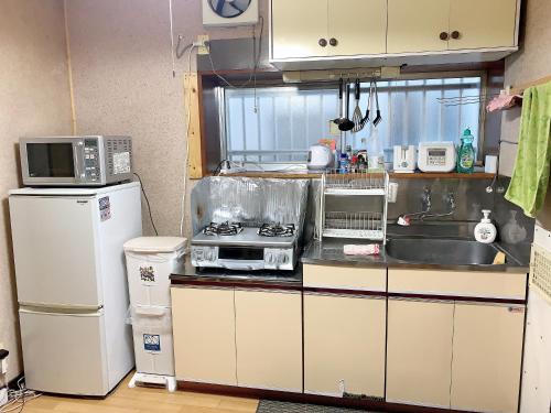 东京Tokyo Kamakura House的厨房配有水槽、炉灶和微波炉