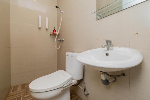 雅加达红门优质酒店 @ 范登巴拉特的浴室配有白色卫生间和盥洗盆。