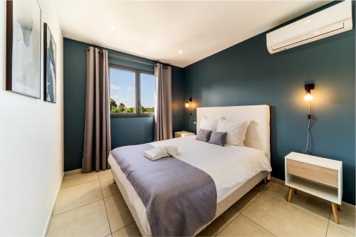 圣若瑟Villa moderne Manapany -Jacuzzi-Proximité mer的一间卧室设有一张蓝色墙壁的大床