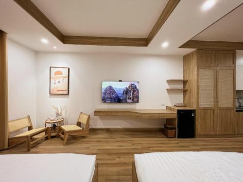 归仁TMS Quy Nhơn - Lee Xinh的一间卧室设有两张床,墙上配有电视。