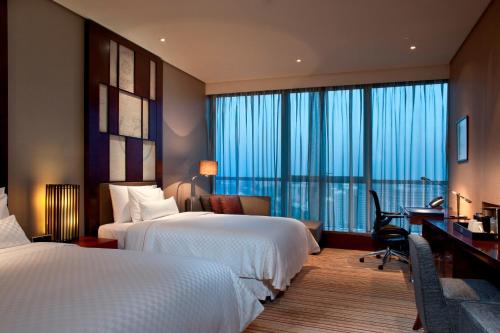 北京北京威斯汀酒店的酒店客房配有两张床和一张书桌