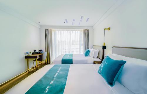 深圳蓬客精品酒店（深圳罗湖宝能中心笋岗地铁站店）的酒店客房设有两张床和窗户。