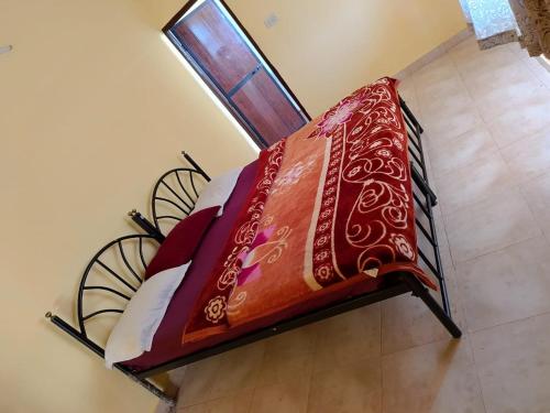 阿伯来Baga the pool resort的一张床上的红色毯子,窗户