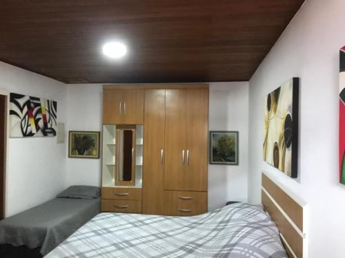 弗洛里亚诺波利斯Apartamento Rafaelli的一间卧室配有一张床和一个木制橱柜