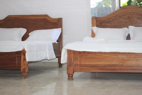 丰博尼Faradel Motel的两张带白色枕头和床单的床